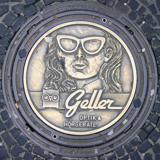 Geller Optik Ad on Mahole Cover